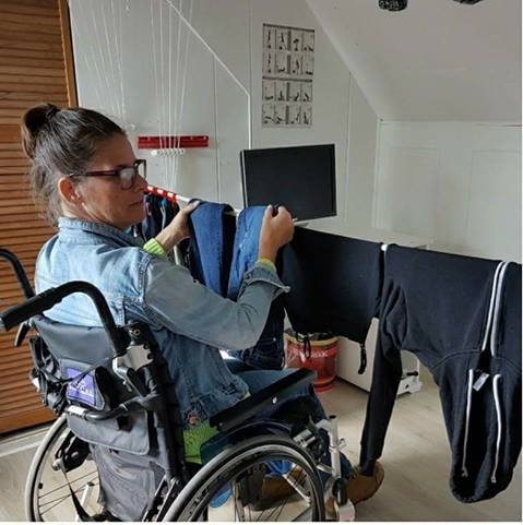 paula hangt zittend de was op een plafonddroogrek